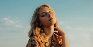 Woman posing outdoors under clear sky.