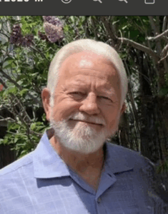 Smiling man with white hair and beard.